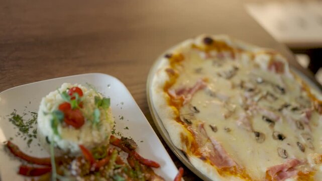 Young woman at a restaurant with a variety of served dishes in front of her, including pizza, spaghetti, lasagna, and Chinese chicken