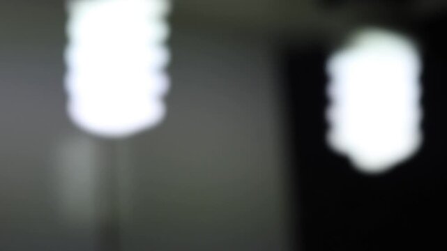 Primer plano de una luz de una lampara con un bombillo de color blanco en movimiento en la oscuridad. C&aacute;mara en movimiento