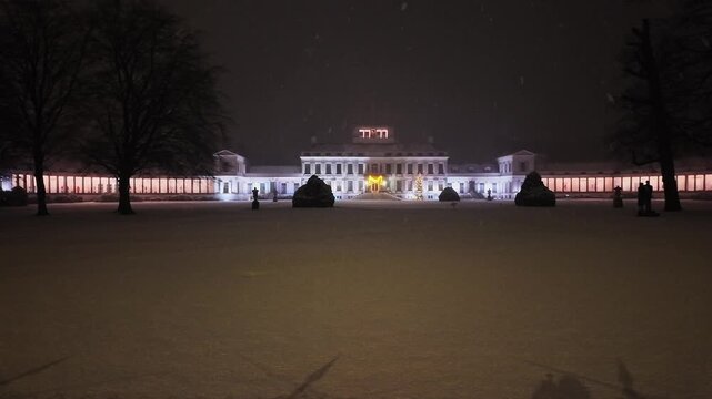Wide view of a beautiful palace with festive lights on a snowy winter night. The palace is Soestdijk palace in the Netherlands, the former living place of the Dutch royal family.