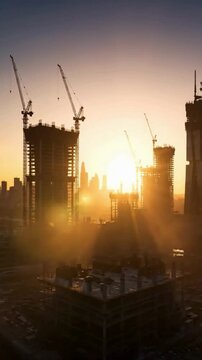 Construction site at sunset with cranes and buildings