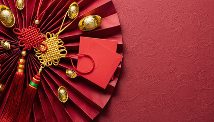 A decorative red fan with gold ornaments on a textured red background