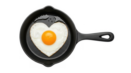 A heart-shaped fried egg cooking in a small cast iron pan for a loving breakfast isolated on transparent background