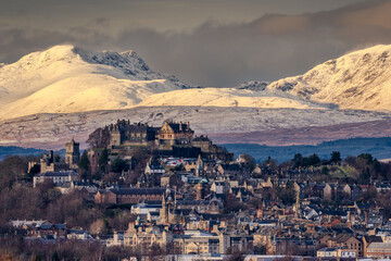 Stirling Castle and snow covered mountains winter sunset.