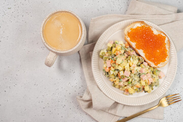 Russian breakfast on January 1st. Olivier salad, toast with butter and red caviar, and coffee.