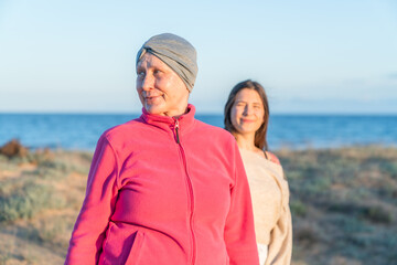 Woman with headscarf and adult daughter on beach © Araguatai