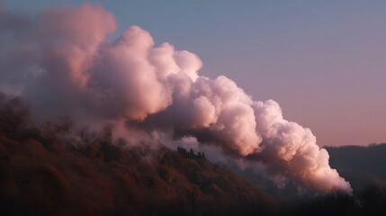 Fototapeta premium A large pink tinged steam plume drifts across a forested hillside at golden hour