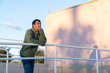 Man leaning on railing contemplating during sunset © Araguatai