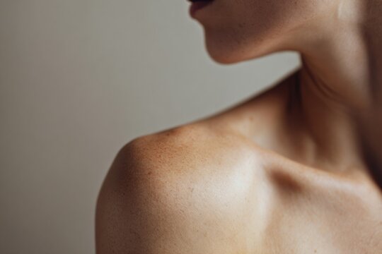 Female shoulder and neck close-up with freckles on light skin tone