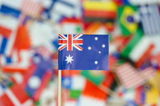 Small Australia flag stands in front of many country flags on a table during a multicultural event held in a community center