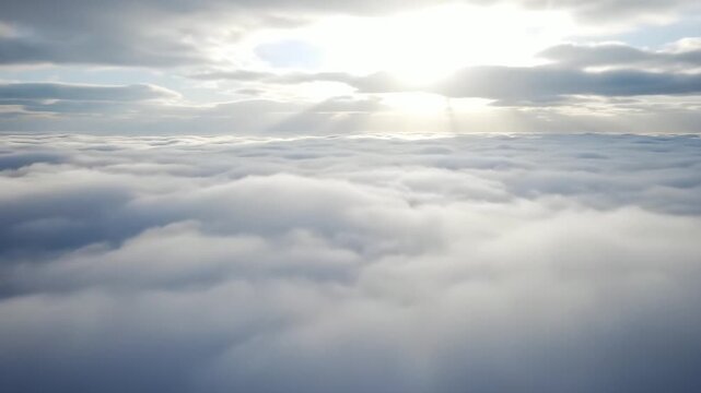 Expansive aerial perspective over a tranquil ocean of white clouds, bathed in the soft glow of golden sun rays piercing through the atmospheric heavens, symbolizing peace and boundless beauty