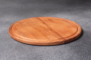 A close-up of a round wooden cutting board