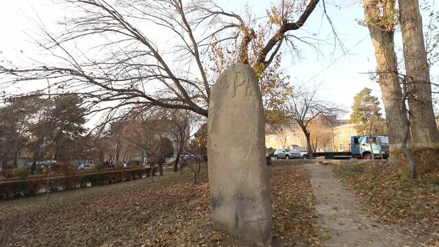 A slow tilt up view of an ancient Deer Stone monument showing intricate carvings and petroglyphs on the surface, dating back to the Bronze Age in Armenia