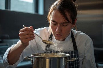 Professional cook tasting soup in modern kitchen with calm focused atmosphere and expertise