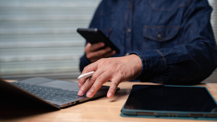 Businessman using laptop smartphone and digital tablet for communication and business work