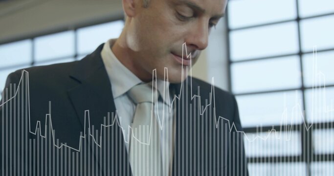 Man in dark suit, light tie analyzing bar and line graph overlay by mullioned windows