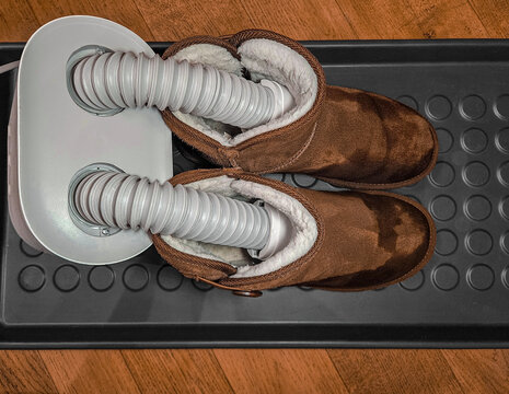 Electric shoe dryer inserted into winter boots for drying and moisture removal indoors