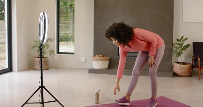 When recording is starting, woman is bending forward on purple mat to adjust shoe fit