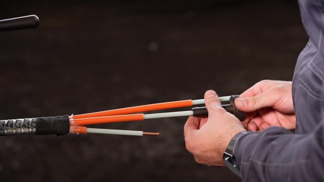 Installer Adds Sleeve, Technician Securely Places Sleeve Over Orange Cores With Precise Alignment