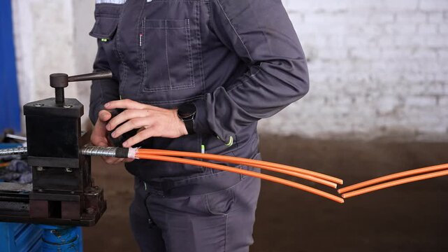 Worker Meticulously Arranging And Measuring Cable Conductors Against Brick Wall Background