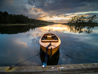 Sch&ouml;nes Holzboot am Steg bei Sonnenuntergang in S&uuml;dschweden