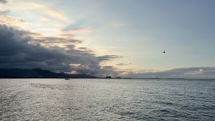 Obraz premium Spectacular panoramic sunset view over the ocean with the coastal city skyline and mountains - Puerto Cabello, Venezuela