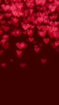 Pink hearts falling on red background for Valentine's day. Heart particles raining down for romantic theme celebrating love, passion, or for a Valentines day background.