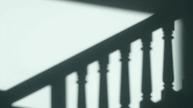 abstract shadow patterns of balusters on a wall creating a modern minimalist backdrop