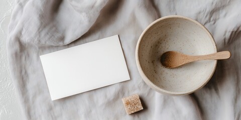 a blank postcard mockup and a simple ceramic sugar bowl on a light gray linen tablecloth