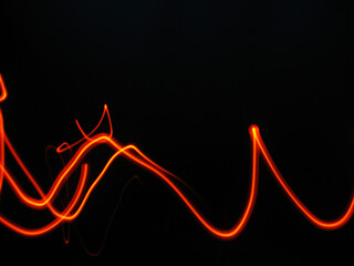 Vibrant orange light trails on black background