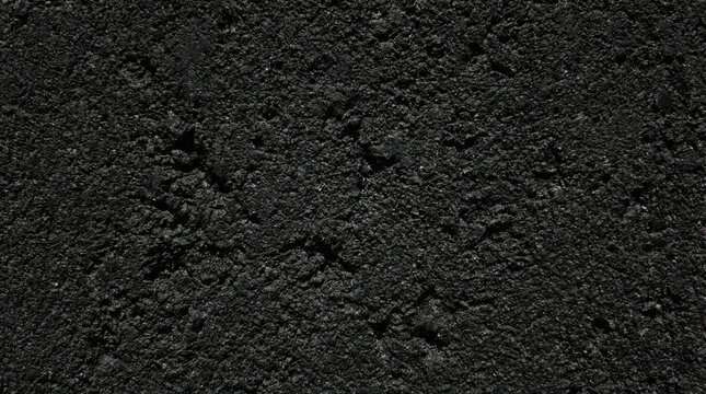 Close-up textured black asphalt surface, rough granular dark pavement background ideal for road construction,industrial texture,design backdrops