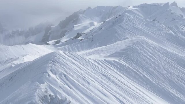 Starting forward-panning drone capturing snow-covered ridge at high alpine, revealing cornices