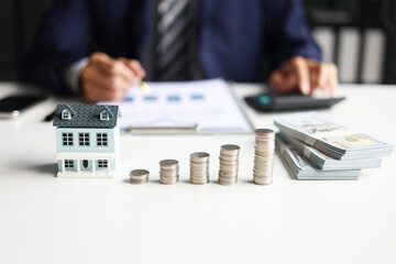 Investing in Real Estate, Real estate agent or investor calculating, planning, analyzing financial data for property investment. Themes of saving, investing, financial aspects of purchasing a home.