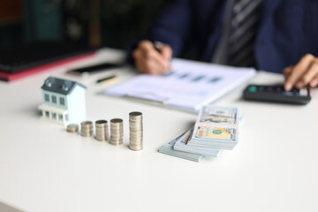 Investing in Real Estate, Real estate agent or investor calculating, planning, analyzing financial data for property investment. Themes of saving, investing, financial aspects of purchasing a home.