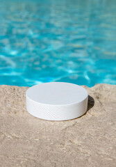 White wooden platform by a blue swimming pool with water, ideal as a product background. Lots of copy space, blurred background.