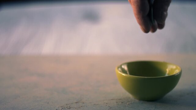 Hand dropping money into a tip jar bowl