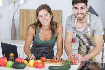 portrait of happy couple preparing vegetables