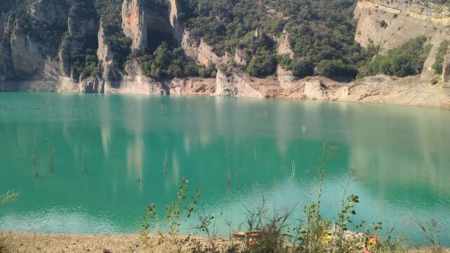 Beautiful turquoise lake surrounded by rugged cliffs. A serene and picturesque landscape. Perfect for outdoor enthusiasts and nature lovers seeking tranquility.