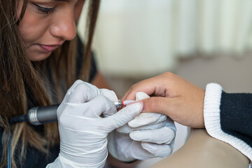 Manicurist working on client nails preparing manicure