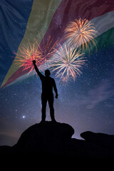 Man against background of a fireworks and national flag of Seychelles