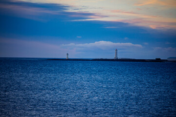 Obraz premium Two lighthouses on the horizon over the sea at dusk, Akranes, Iceland