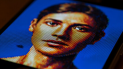 Close-up of a vibrant pixelated human face on a digital screen, representing AI, data, and future tech