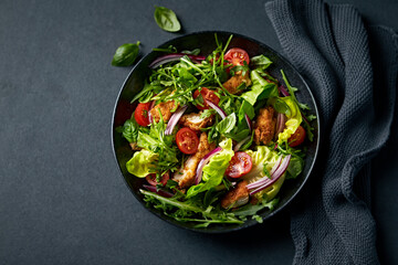 Chicken salad with greens, cherry tomatoes, red onion and fresh herbs. Copy space