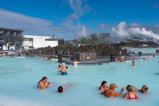 Blue Lagoon geothermal spa in Iceland with people relaxing in warm blue water. Famous Iceland attraction with steam, volcanic rocks, and peaceful outdoor bathing scene in the Blue Lagoon.