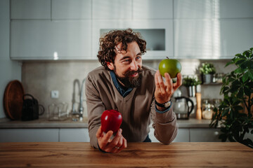 Man choosing between red and green apple for healthy eating
