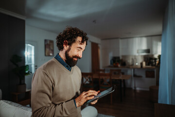 Adult man enjoying connectivity using digital tablet at home
