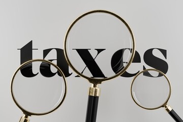 3 magnifying glasses hovering over text saying taxes, tax return, taxation