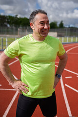 Obraz premium Mature man exercising on running track with smartwatch