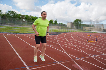 Fototapeta premium Man running on athletics track for fitness training