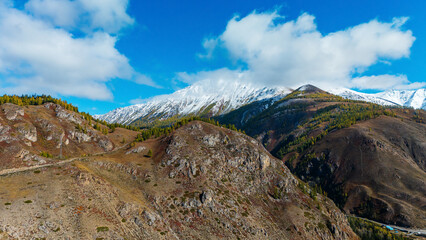 mountain peaks in the Altai region covered with the first snow in autumn, as seen from a drone