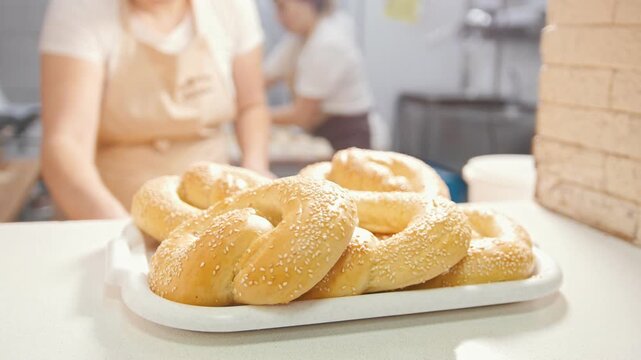 Cook put the fresh hot pastries with sesame in the bakery